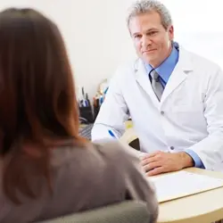 Image of clinician talking with patient at desk