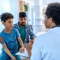 Image of adolescent and adult talking to clinician
