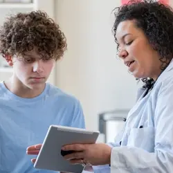 Image of clinician reviewing educational material with pediatric patient